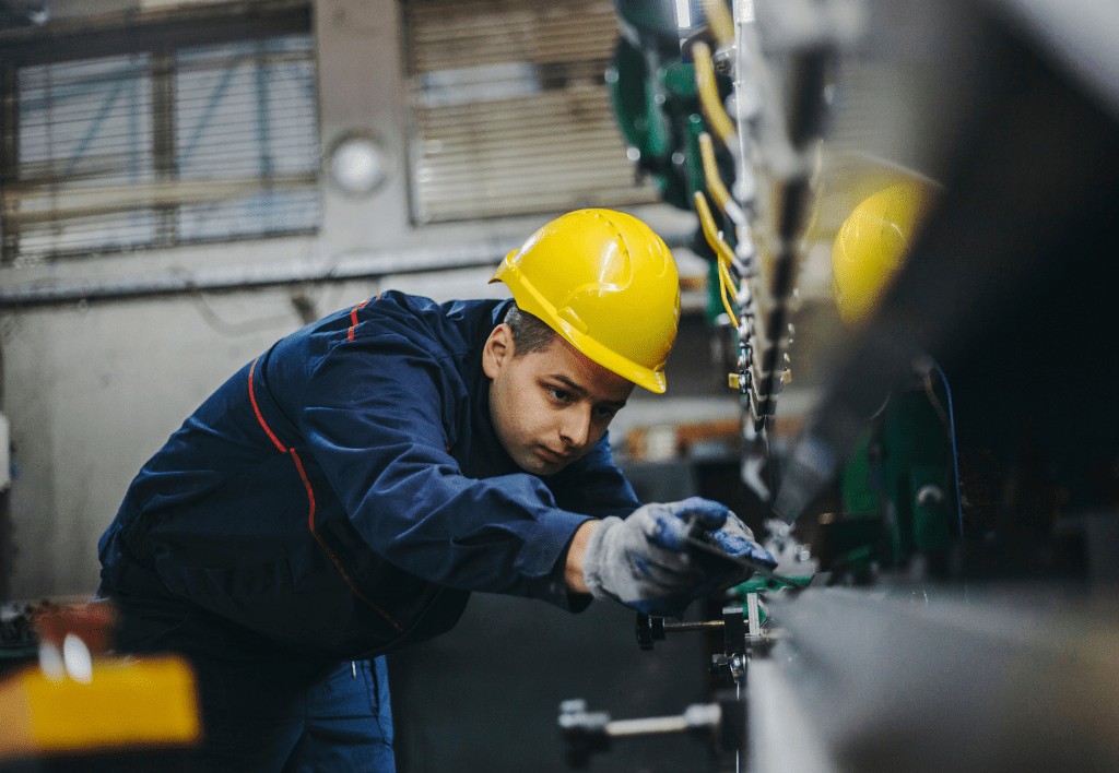 Metal worker operating a sheet press machine